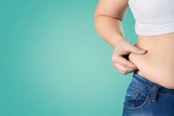 Image of woman pinching her love handles to show weight gain Walsall Wood